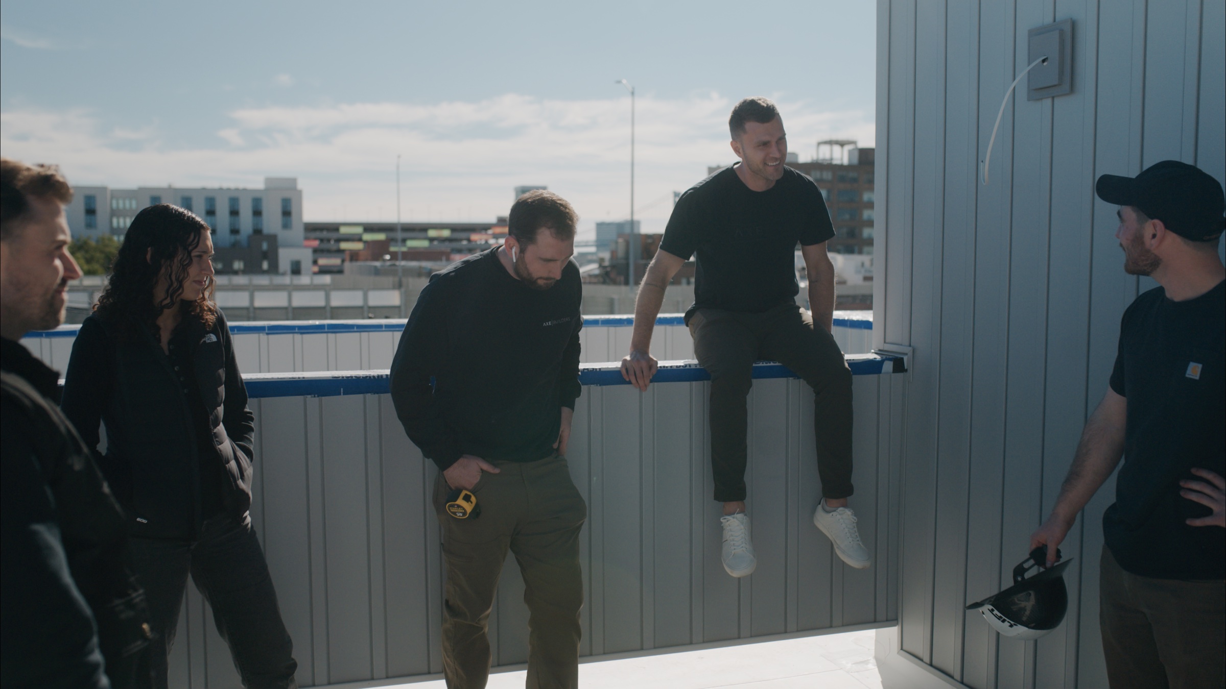 AXE team sharing a conversation on a rooftop construction site